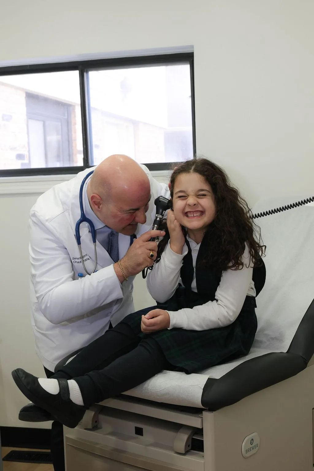 A provider examining a young patient's ear during a routine visit