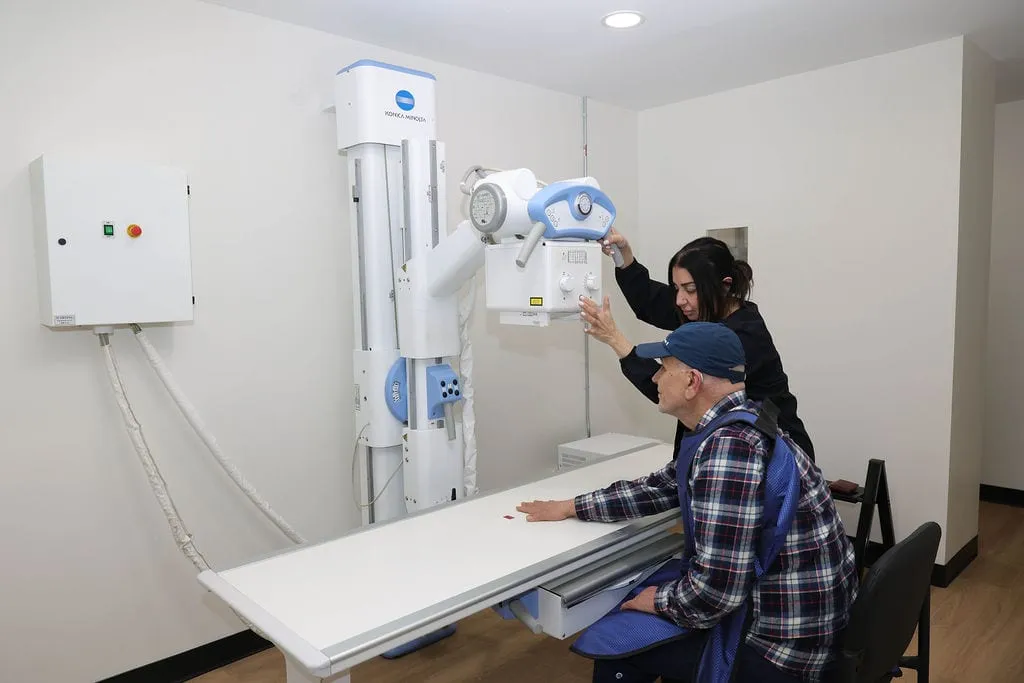 A technologist positioning a patient at the on-site digital X-ray machine