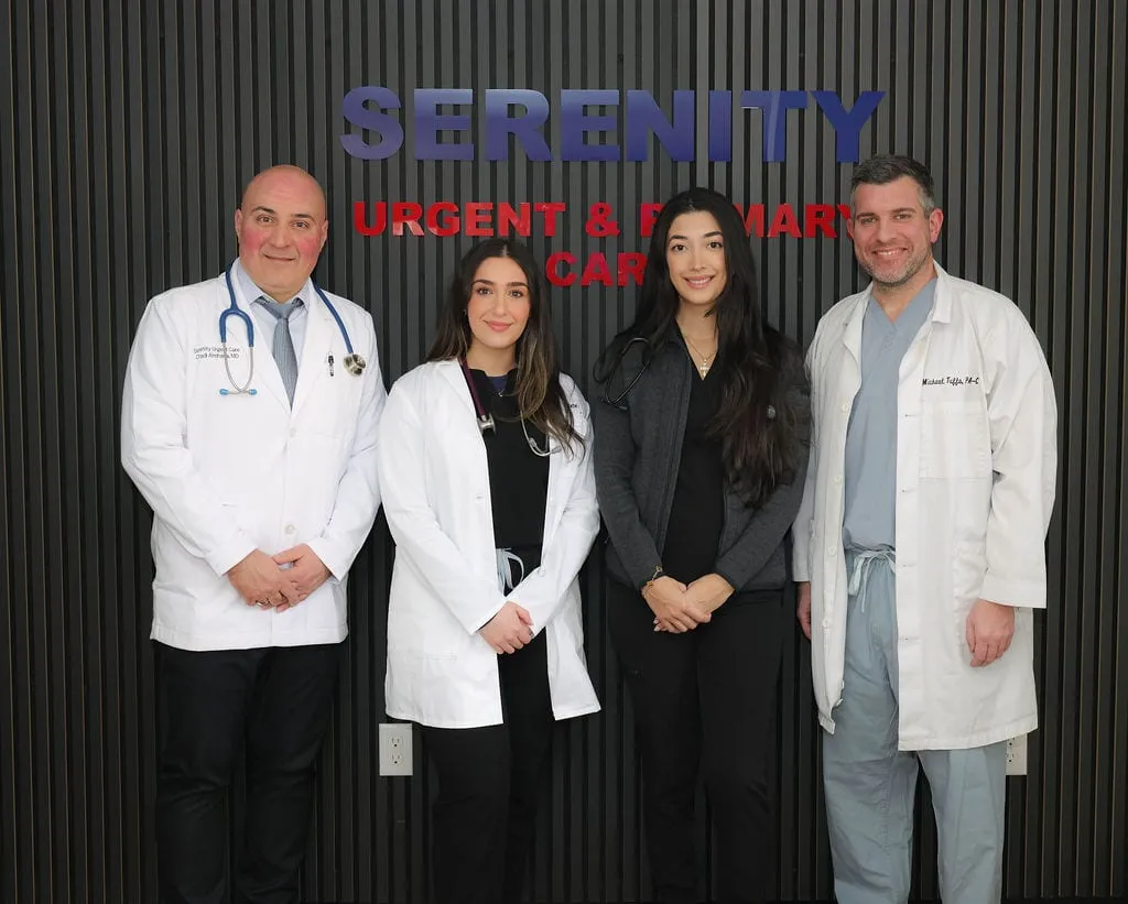 Providers and staff of Serenity Urgent Care in front of the clinic's lobby sign