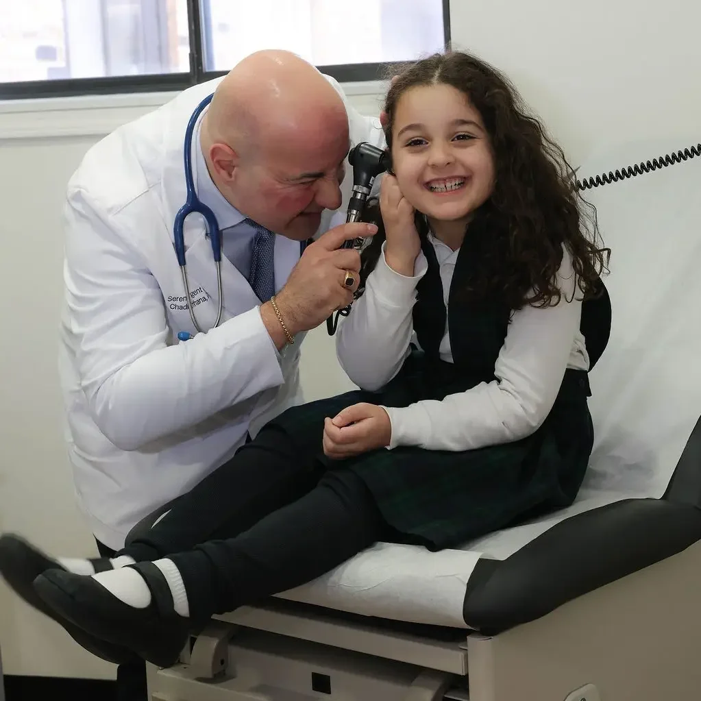 Doctor performing a pediatric exam for a child at Serenity Urgent Medical Care in Livonia